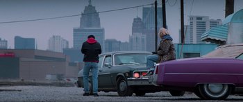 Movie still from “True Romance” (1993), directed by Tony Scott – A man and a woman standing next to a parked car; Wide shot, Over the shoulder angle