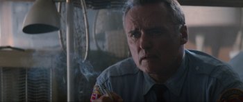 Movie still from “True Romance” (1993), directed by Tony Scott – An older man smoking a cigarette in front of a mirror; Close Up shot, Low angle