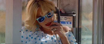 Movie still from “True Romance” (1993), directed by Tony Scott – A woman wearing sunglasses talking on a phone; Close Up shot, Low angle