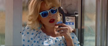 Movie still from “True Romance” (1993), directed by Tony Scott – A woman in a polka dot dress talking on a phone; Close Up shot, Low angle