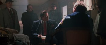 Movie still from “True Romance” (1993), directed by Tony Scott – A group of men sitting around a table; Medium shot, Low angle
