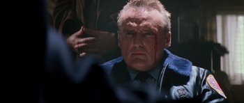 Movie still from “True Romance” (1993), directed by Tony Scott – An older man with blood on his face; Close Up shot, Over the shoulder angle