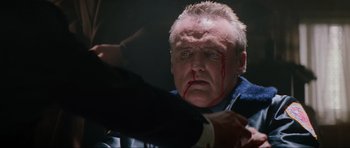 Movie still from “True Romance” (1993), directed by Tony Scott – A person with blood on his face; Close Up shot, Over the shoulder angle