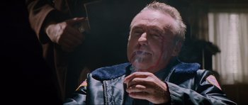 Movie still from “True Romance” (1993), directed by Tony Scott – An older man smoking a cigarette with blood on his face; Close Up shot, Low angle