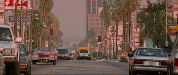 Movie still from “True Romance” (1993), directed by Tony Scott – A street scene with cars driving down the road; Extreme Wide shot, High angle