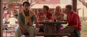Movie still from “True Romance” (1993), directed by Tony Scott – A group of people sitting at a picnic table; Medium shot, Over the shoulder angle