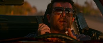 Movie still from “True Romance” (1993), directed by Tony Scott – A person in a car smoking a cigarette; Close Up shot, Low angle