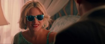 Movie still from “True Romance” (1993), directed by Tony Scott – A woman wearing sunglasses and smiling for the camera; Close Up shot, Over the shoulder angle