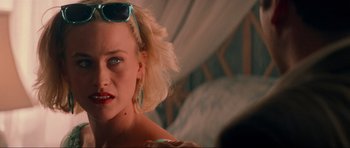 Movie still from “True Romance” (1993), directed by Tony Scott – A blonde woman with sunglasses is posing for a picture; Close Up shot, Over the shoulder angle