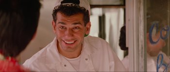 Movie still from “True Romance” (1993), directed by Tony Scott – A man in a chef's outfit smiling for the camera; Close Up shot, Low angle