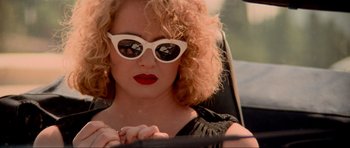 Movie still from “True Romance” (1993), directed by Tony Scott – A woman sitting in a car wearing sunglasses; Close Up shot, Over the shoulder angle