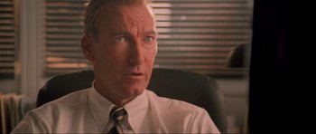 Movie still from “True Romance” (1993), directed by Tony Scott – A person sitting in a chair wearing a tie; Close Up shot, Low angle