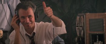 Movie still from “True Romance” (1993), directed by Tony Scott – A man giving a thumbs up in front of a microphone; Close Up shot, Low angle