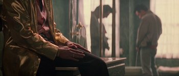 Movie still from “True Romance” (1993), directed by Tony Scott – A man standing in front of a window with his hand on a woman's lap; Medium shot, Over the shoulder angle