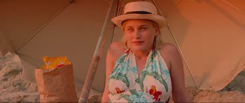 Movie still from “True Romance” (1993), directed by Tony Scott – A woman wearing a hat and a floral dress; Close Up shot, Low angle