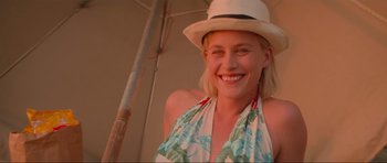 Movie still from “True Romance” (1993), directed by Tony Scott – A woman wearing a white hat and a blue and white dress; Close Up shot, Low angle
