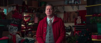 A man wearing a red jacket standing in a room