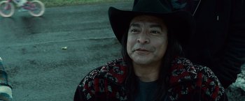 Movie still from “Twilight” (2008), directed by Catherine Hardwicke – A man with long black hair wearing a black hat; Close Up shot, Over the shoulder angle