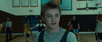 Movie still from “Twilight” (2008), directed by Catherine Hardwicke – A young man in a gym with a group of people in the background; Close Up shot, Low angle
