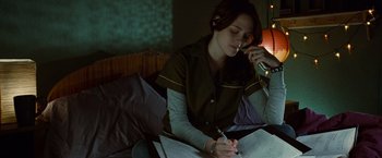 Movie still from “Twilight” (2008), directed by Catherine Hardwicke – A woman sitting on a bed writing on a piece of paper; Medium shot, High angle