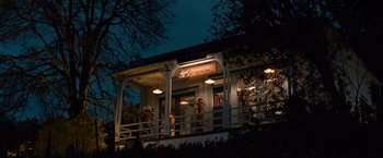 Movie still from “Twilight” (2008), directed by Catherine Hardwicke – A building with a porch at night with lights on it; Extreme Wide shot, Low angle