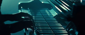 Movie still from “Twilight” (2008), directed by Catherine Hardwicke – A person playing a grand piano in a dark room; Extreme Close Up shot, High angle
