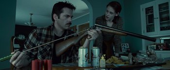 Movie still from “Twilight” (2008), directed by Catherine Hardwicke – A man and a woman are holding guns and beer cans; Medium shot, Low angle