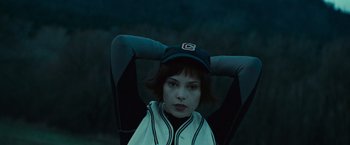 Movie still from “Twilight” (2008), directed by Catherine Hardwicke – A woman with a baseball cap is sitting in a chair; Close Up shot, Low angle