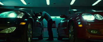Movie still from “Twilight” (2008), directed by Catherine Hardwicke – A man standing in front of two cars in a garage; Wide shot, Low angle