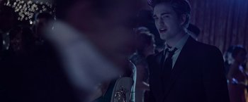 Movie still from “Twilight” (2008), directed by Catherine Hardwicke – A man in a suit and tie standing in a room; Medium shot, Over the shoulder angle