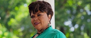 Movie still from “Tyler Perry's A Madea Homecoming” (2022), directed by Tyler Perry – An older woman wearing a green shirt and green necklace; Close Up shot, Over the shoulder angle
