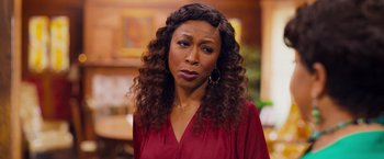 Movie still from “Tyler Perry's A Madea Homecoming” (2022), directed by Tyler Perry – A person with curly hair wearing a red shirt; Close Up shot, Over the shoulder angle