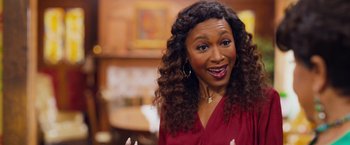 Movie still from “Tyler Perry's A Madea Homecoming” (2022), directed by Tyler Perry – A person with curly hair smiling; Close Up shot, High angle