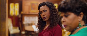 Movie still from “Tyler Perry's A Madea Homecoming” (2022), directed by Tyler Perry – A person with curly hair wearing a red shirt; Close Up shot, Over the shoulder angle