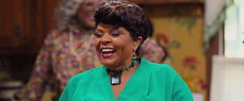 Movie still from “Tyler Perry's A Madea Homecoming” (2022), directed by Tyler Perry – An older woman wearing a green shirt and a green necklace; Close Up shot, Over the shoulder angle