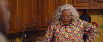 Movie still from “Tyler Perry's A Madea Homecoming” (2022), directed by Tyler Perry – A woman in a floral print shirt and glasses; Close Up shot, Low angle