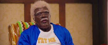 Movie still from “Tyler Perry's A Madea Homecoming” (2022), directed by Tyler Perry – An older man wearing glasses and a blue jacket; Medium shot, High angle