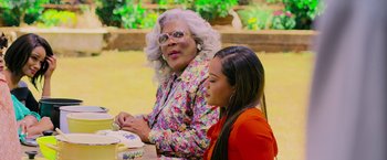 Movie still from “Tyler Perry's A Madea Homecoming” (2022), directed by Tyler Perry – Two women sitting at a table in front of each other; Medium shot, Over the shoulder angle