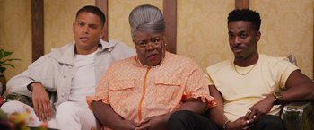 Movie still from “Tyler Perry's A Madea Homecoming” (2022), directed by Tyler Perry – An older woman sitting in front of a group of other people; Close Up shot, Over the shoulder angle