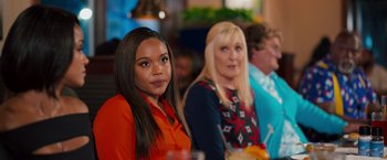 Movie still from “Tyler Perry's A Madea Homecoming” (2022), directed by Tyler Perry – Two women are sitting at a table in front of a drink; Medium shot, Over the shoulder angle