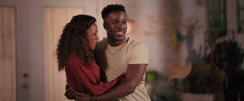 Movie still from “Tyler Perry's A Madea Homecoming” (2022), directed by Tyler Perry – A man and a woman are hugging and smiling for the camera; Medium shot, Over the shoulder angle