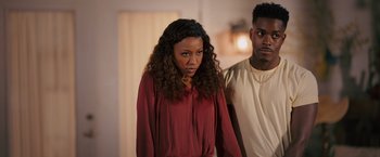 Movie still from “Tyler Perry's A Madea Homecoming” (2022), directed by Tyler Perry – A woman standing next to a man in a room; Medium shot, Over the shoulder angle