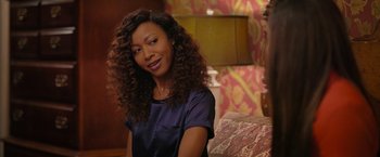 Movie still from “Tyler Perry's A Madea Homecoming” (2022), directed by Tyler Perry – A woman sitting on a couch in front of a lamp; Close Up shot, Over the shoulder angle