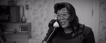 Movie still from “Tyler Perry's A Madea Homecoming” (2022), directed by Tyler Perry – An older woman talking on a phone while wearing gloves; Close Up shot, High angle