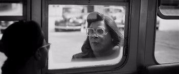 Movie still from “Tyler Perry's A Madea Homecoming” (2022), directed by Tyler Perry – Black and white photograph of a woman looking out of a window; Medium shot, Over the shoulder angle