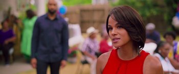 Movie still from “Tyler Perry's A Madea Homecoming” (2022), directed by Tyler Perry – A woman in a red dress is standing in front of other people; Close Up shot, Over the shoulder angle