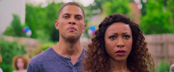 Movie still from “Tyler Perry's A Madea Homecoming” (2022), directed by Tyler Perry – A man and a woman standing next to each other in front of trees; Close Up shot, Low angle