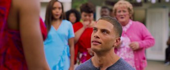 Movie still from “Tyler Perry's A Madea Homecoming” (2022), directed by Tyler Perry – A group of people standing around a man with his eyes wide open; Close Up shot, Over the shoulder angle