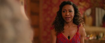 Movie still from “Tyler Perry's A Madea Homecoming” (2022), directed by Tyler Perry – A person with curly hair wearing a necklace; Close Up shot, Over the shoulder angle