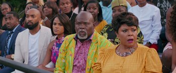 Movie still from “Tyler Perry's A Madea Homecoming” (2022), directed by Tyler Perry – A group of people that are standing in a room; Close Up shot, Over the shoulder angle
